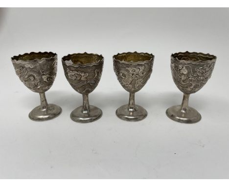 A set of four Chinese silver coloured metal egg cups, decorated dragons, 6.5 cm high (4)Slight out of shape see images 141.2 