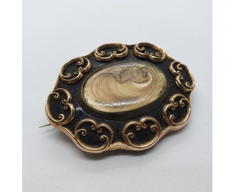 A Victorian yellow coloured metal and black enamel memorial brooch, inset with a lock of hairAll in weight 26 g, very worn, s