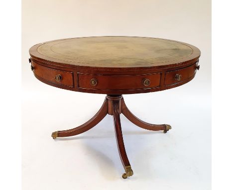 A George III style mahogany drum top table, the leather inset top above four real and four false drawers, on a column with sp