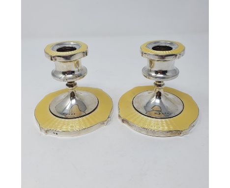 A pair of George V silver and yellow enamel candlesticks, Birmingham 1930, 9 cm highFilled, small losses to enamel to base ar