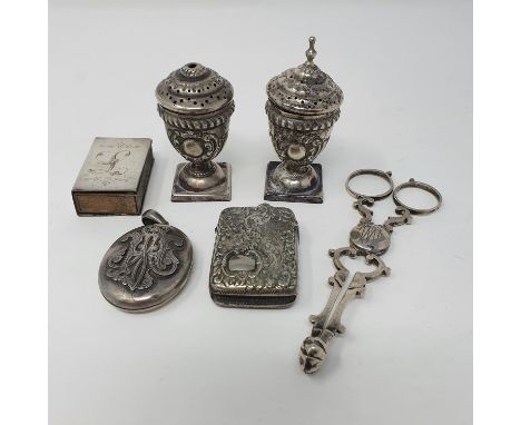 A pair of Victorian silver tongs, Birmingham 1881, two pepper pots, a matchbox holder, a vesta and an oval locket, various da