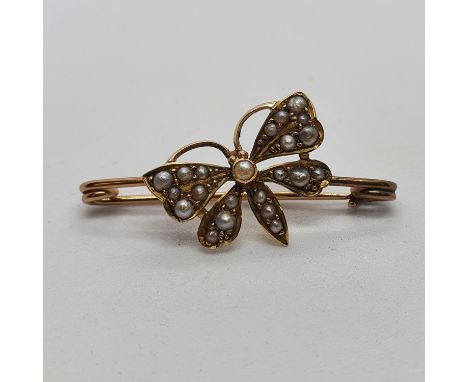 A late 19th/ early 20th century yellow coloured metal and seed pearl stick pin, in the form of a butterfly 