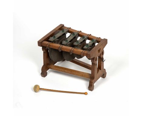 An early 20th century musical bell chime xylophone with four copper and brass bells of flattened form on oak stand, 31.5cm wi