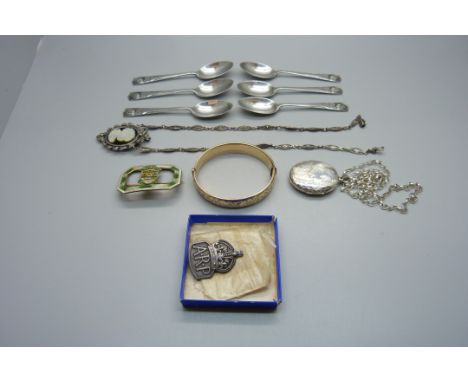 Six commemorative silver teaspoons, 55g, a silver ARP badge, an 18ct gold plated bangle, a silver locket and chain, a silver 