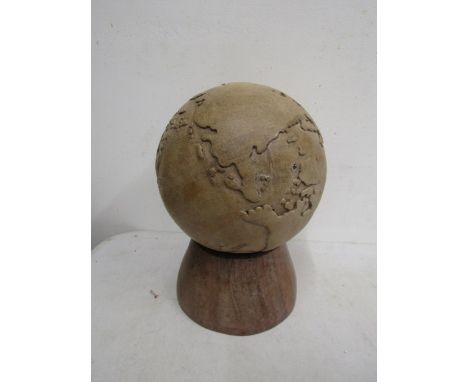 A solid wooden globe on stand