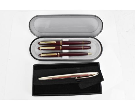 A cased set of pens, comprising two fountain and one ballpoint pen, each with maroon barrel and gilt clip and rings, unknown 