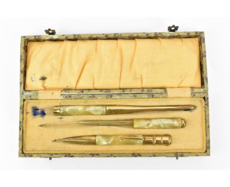 An early 20th century Art Deco cased desk set, in marbled bakelite and gold coloured metal, comprising a pencil, a letter ope