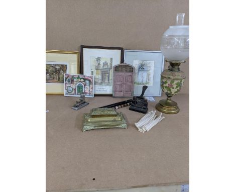 A Mixed lot to include a brass inkwell stand, a brass and floral oil lamp, vintage hole punch and staple gun, three framed an