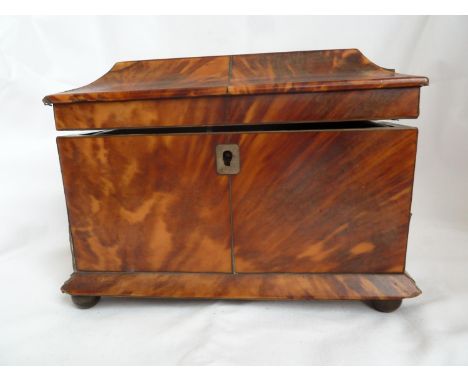 A Tortoiseshell tea caddy, 19th Century, of rectangular section on bun feet, the hinged cover opening to reveal two covered c