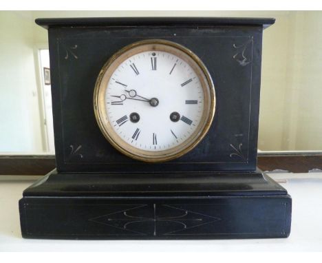 A slate mantel clock, the glass back opening to reveal striking mechanism, with key, h 20 cm x w 21cm x d 13.5cm 