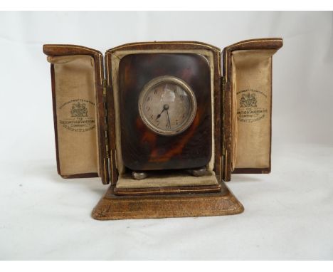 A Goldsmiths &amp; Silversmiths Company cased tortoiseshell veneer travelling clock, with key (3) 