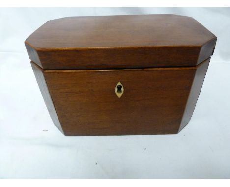 A mahogany tea caddy, of canted rectangular form, set with a bone escutcheon, the hinged cover lifting to reveal two covered 