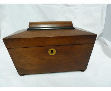 A mahogany tea caddy, of sarcophagus form on flattened bun feet, the hinged cover lifting to reveal two covered compartments 