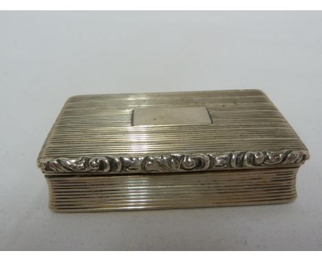 A Georgian silver snuff box, of rectangular form the exterior reeded about a vacant rectangular reserve, with foliate scroll 