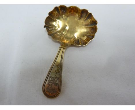 A Georgian silver gilt caddy spoon, crested, the bowl of fluted rectangular form, the crest of the Paschal Lamb and tree, Lon
