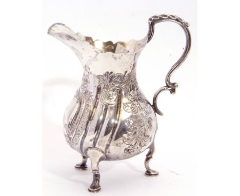 Late Victorian embossed pear-shaped cream jug in George II style, having card cut rim, leaf capped double C scroll handle and