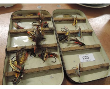 A vintage tin box containing a selection of fishing fly's