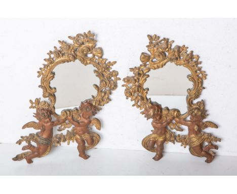 2-teiliges Set von Spiegeln (wohl 19. Jh.), Messing, Rahmung m. Floral- u. Rocaillendekor,je 2 Putti am unteren Rand, H. ca. 