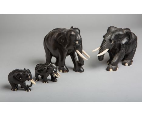 4-teiliges Konvolut von Elefanten (wohl Afrika), Holz m. Elfenbeinelementen, versch.Größen. Sprünge, 1 Elefant unfachm. repar