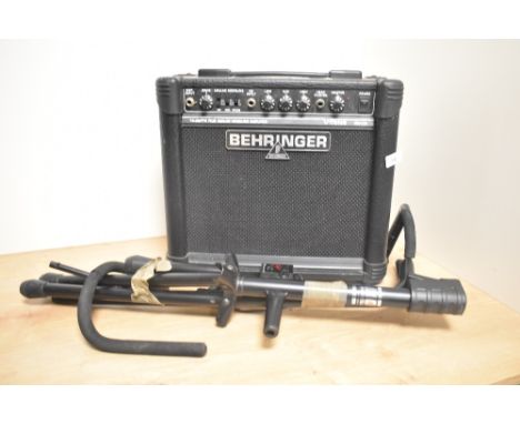 A Behringer portable amplifier and a guitar stand.