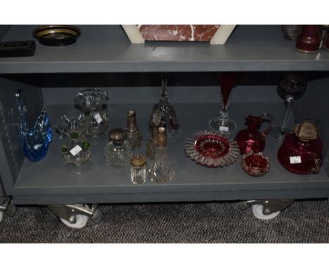 A selection of glassware, including cranberry glass oil lamp base, jug and pinch pots, blue art glass swan and cut glass perf