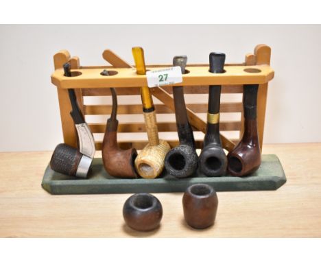 A vintage pipe rack and six tobacco pipes.