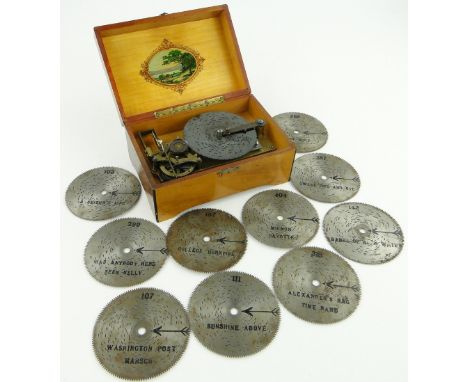 A small cased Polyphon with scene of Dutch figures to the lid,
and a selection of discs, diameter 4.5".