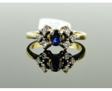 A sapphire and diamond cluster ring,
sapphire height 4mm, flanked by 6 small diamonds, unmarked gold settings, size M.