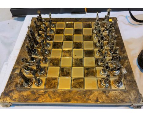 A brass chess set with matching mottled board; a small white &amp; gilt metal chess set with leather board &amp; case 