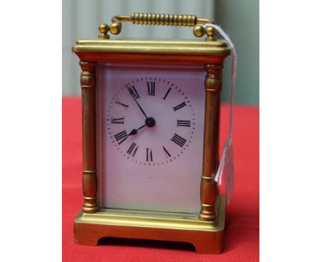 A brass cased carriage clock. dial with Roman numerals, having key