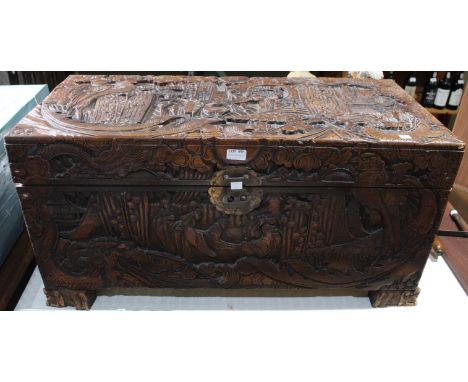 A carved Far Eastern camphor wood trunk, with side handles and clasp, 93cm wide