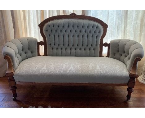 An Edwardian walnut framed sofa, with boxwood line inlay, deep button back and double end, width 70ins