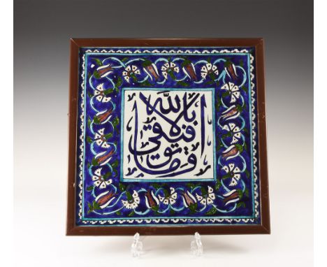 20th century AD. A glazed ceramic tile with central panel of calligraphic text within a border of flowers and tendrils; mount