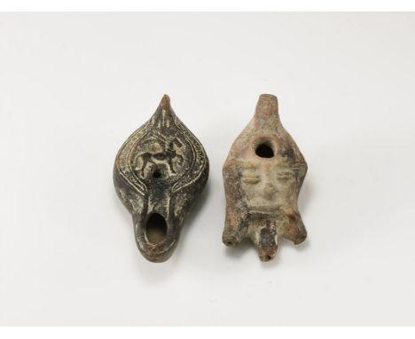 2nd-4th century AD. A mixed pair of ceramic oil lamps comprising: a bearded mask with hole to the forehead, three nozzles for
