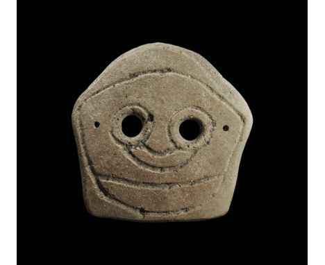 4th-3rd century BC. A trapezoidal domed ceramic mask with two eye-holes and incised stylised facial details; pierced for atta