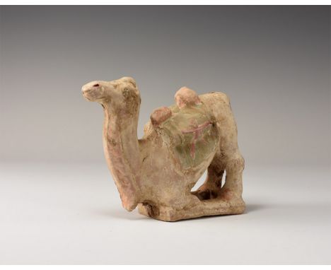. An undated archaistic ceramic kneeling camel statuette with panniers. From a central London collection formed between 1990-
