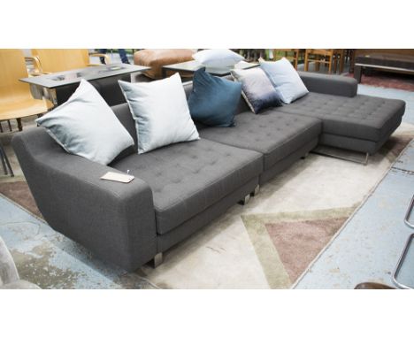 SOFA, modular in three sections, bought from Selfridges, metal supports, in buttoned grey fabric with cushions, 296cm L x 64c