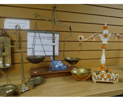 A set of vintage brass balance scales together with a painted floral set and another brass set with incorporated weights to t