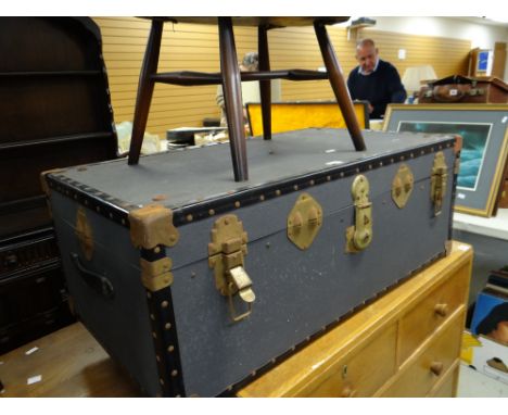 An Ercol tub-type chair together with a vintage steamer trunk