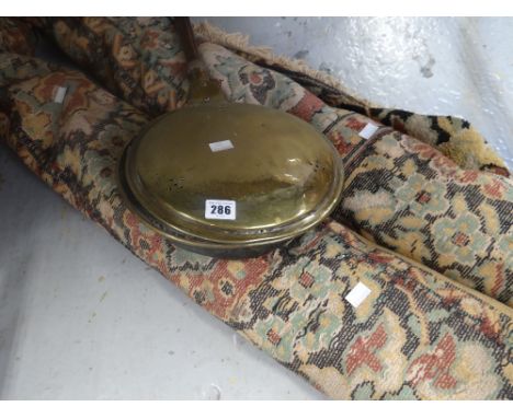 A vintage Persian carpet and a brass turned handle warming pan