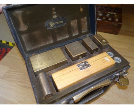 A vintage leather cased set of weights with fitted wooden box
