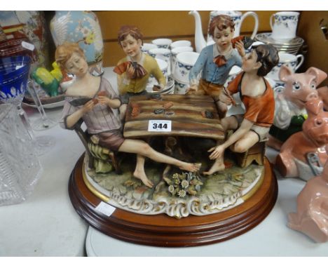 A Capodimonte pottery sculpture of four card playing youthsThere is some damage. The card has broken off the foot of one of t