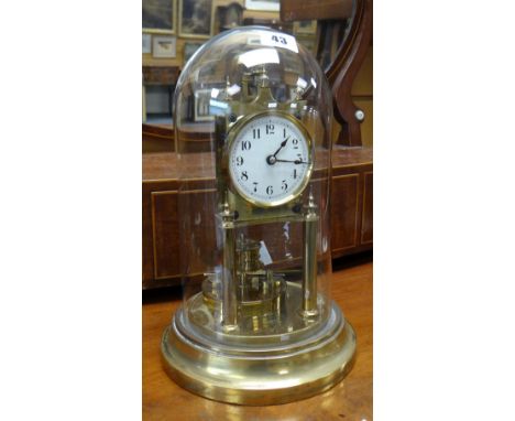 A vintage brass and glass domed perpetual clock