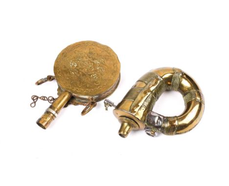 A North African circular embossed brass "powder" flask, 4" diameter, with white metal overlay and two hanging rings; and a br