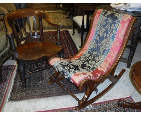 A Victorian walnut framed rocking chair with turned and ringed front supports and red, black and green upholstery with floral