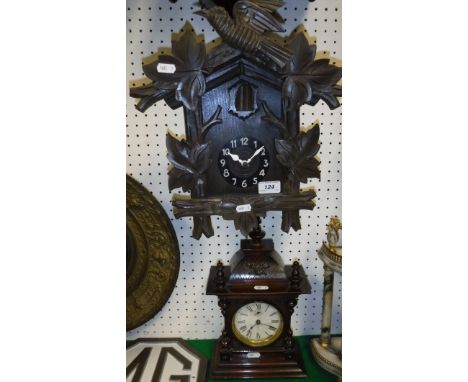 A Black Forest or Alpine style cuckoo clock with carved decoration and a Junghans mantle clock in a walnut case
