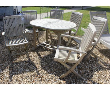 A modern Lindsey International teak garden furniture set comprising extending table and six chairs (2 + 4) all of slatted for