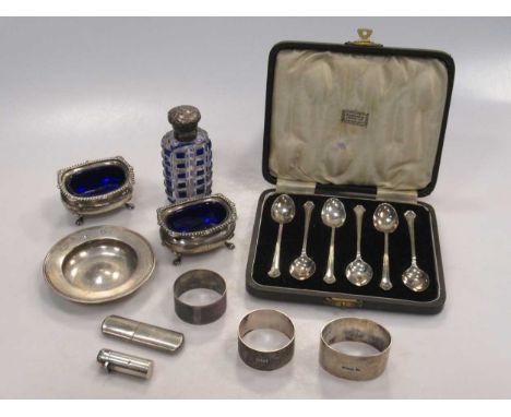 A pair of silver salts, napkin rings, cased spoons and a small dish, a metal mounted scent bottle, a small silver flask with 