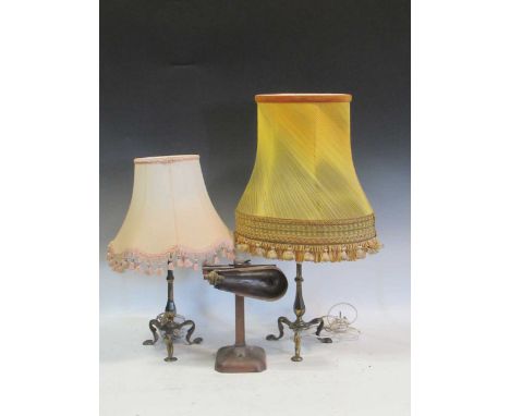 A pair of brass lamps with tripod bases and a desk lamp