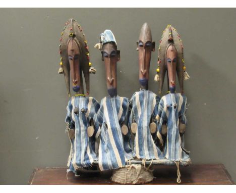 A set of four Bamana style carved wood puppet figures on stand 76cm high, 60cm wide